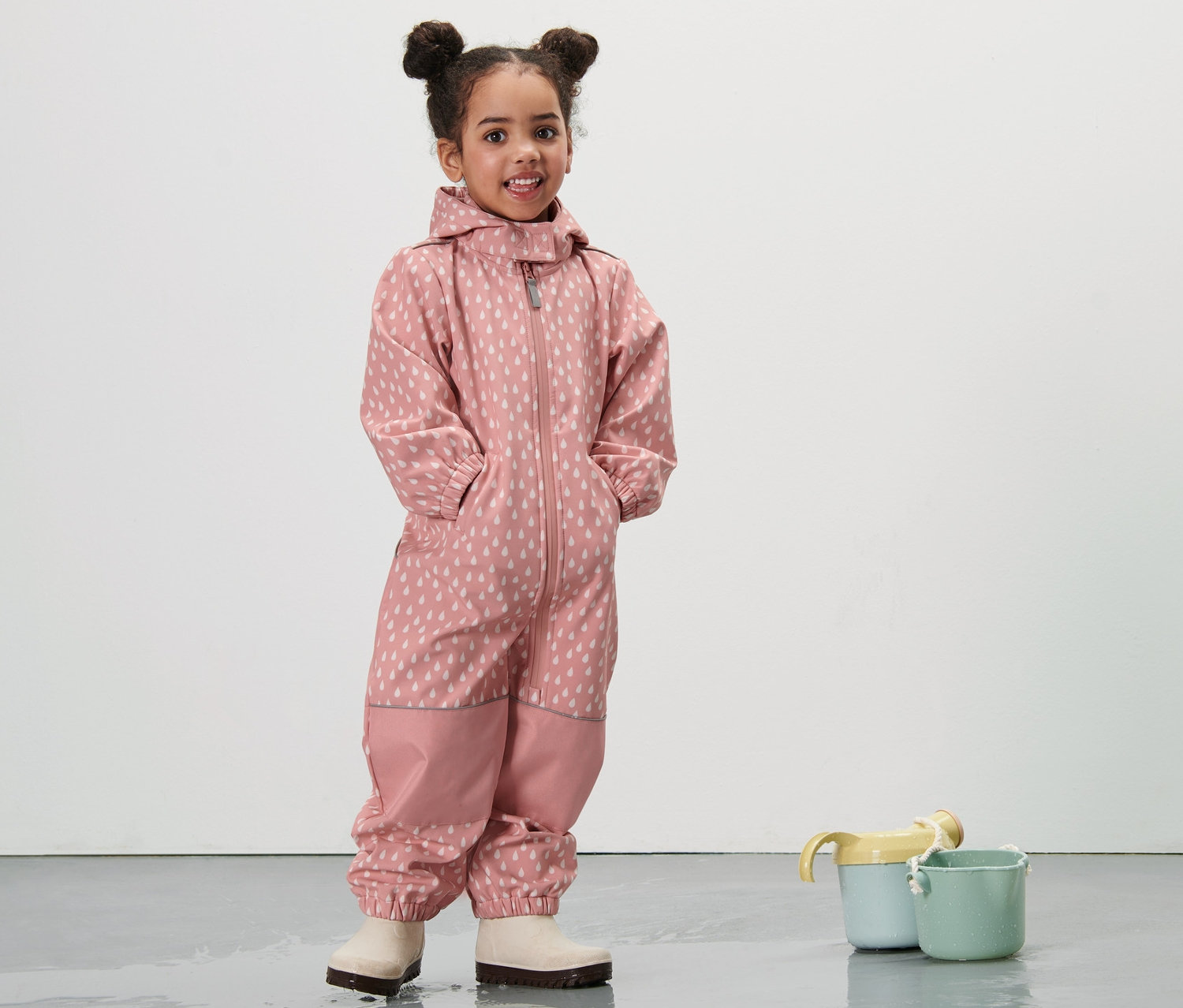 Küçük bir kız, Damlalı Pembe Küçük Çocuk Softshell Tulum giyiyor.