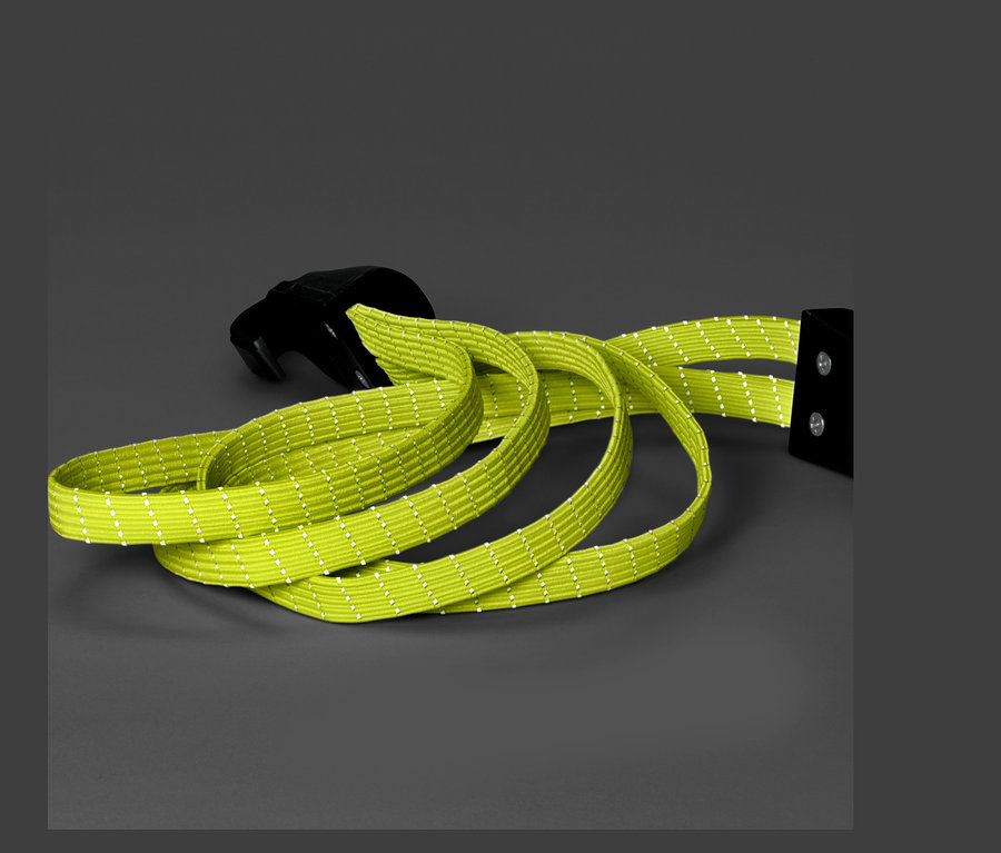 Gri bir arka plan üzerinde siyah tokalı yeşil bir bisiklet bagaj lastiği.