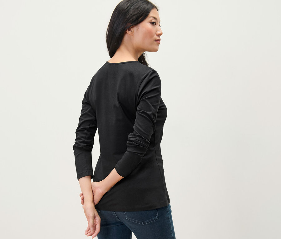 Kadın siyah uzun kollu tişört giyiyor.