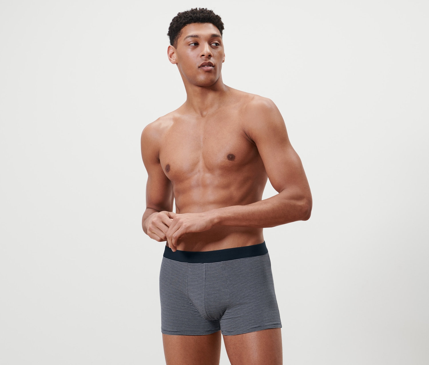 Beyaz bir arka planda 2 Adet Slip Boxer ile poz veren bir adam.
