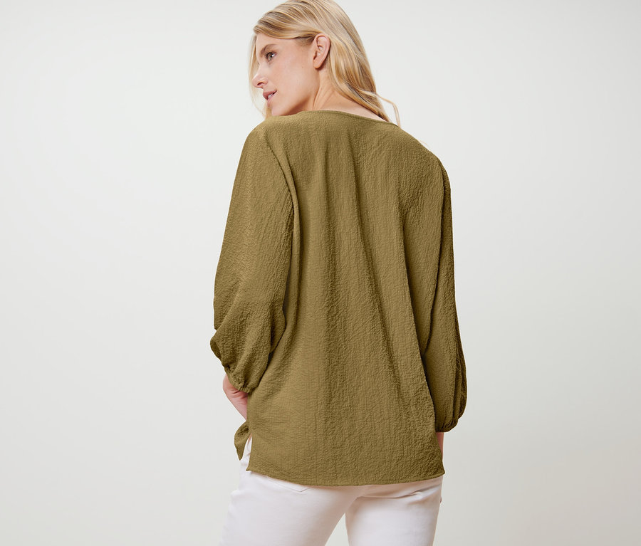 Bir kadın Tunik Bluz ile kameraya arkası dönük duruyor.