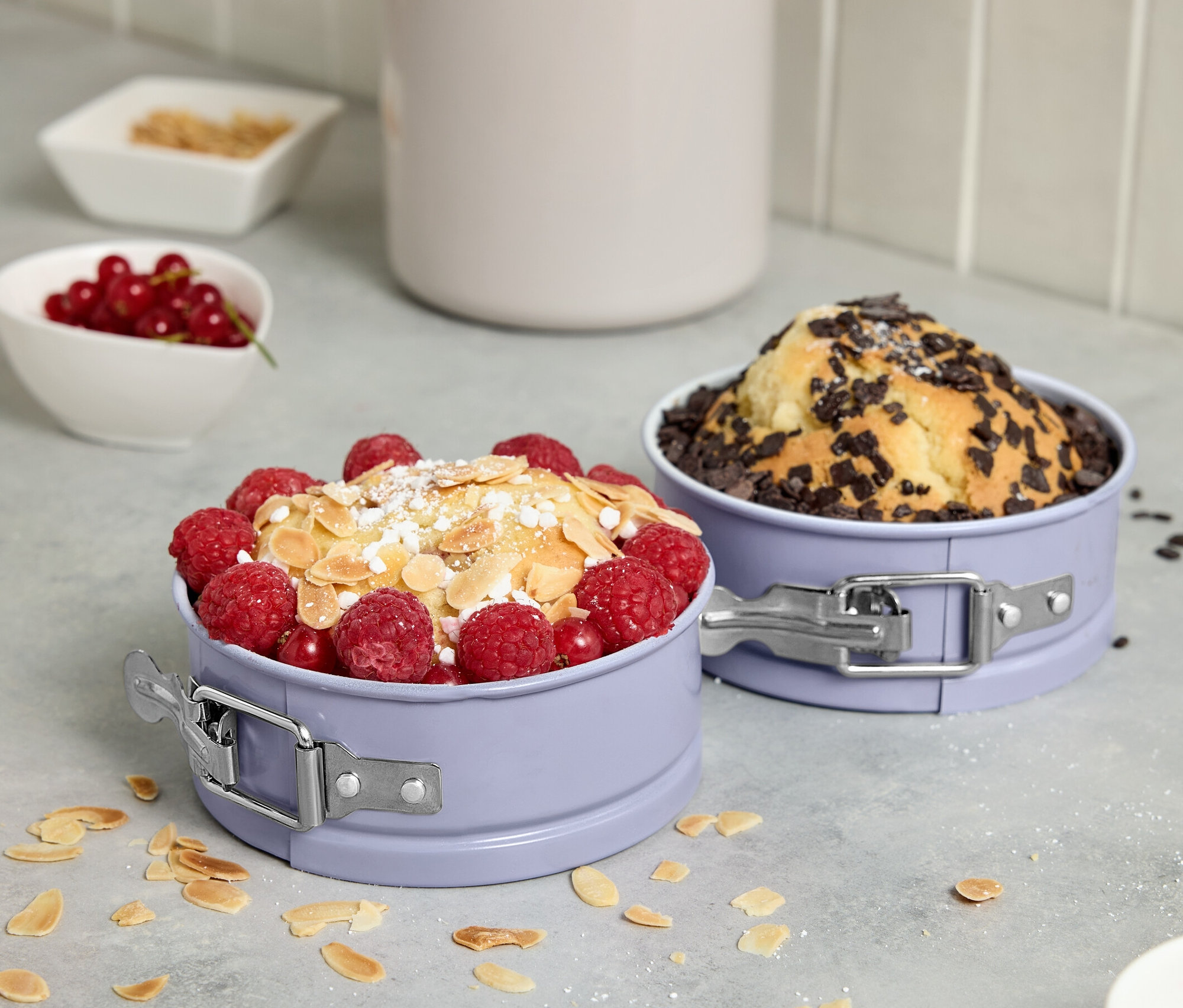 Meyve ve çikolata ile süslenmiş kek içeren iki adet mini kelepçeli kalıp.