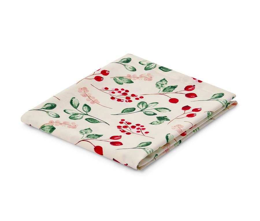 Katlanmış, kırmızı meyveli ve yeşil yapraklı pamuklu masa örtüsü.