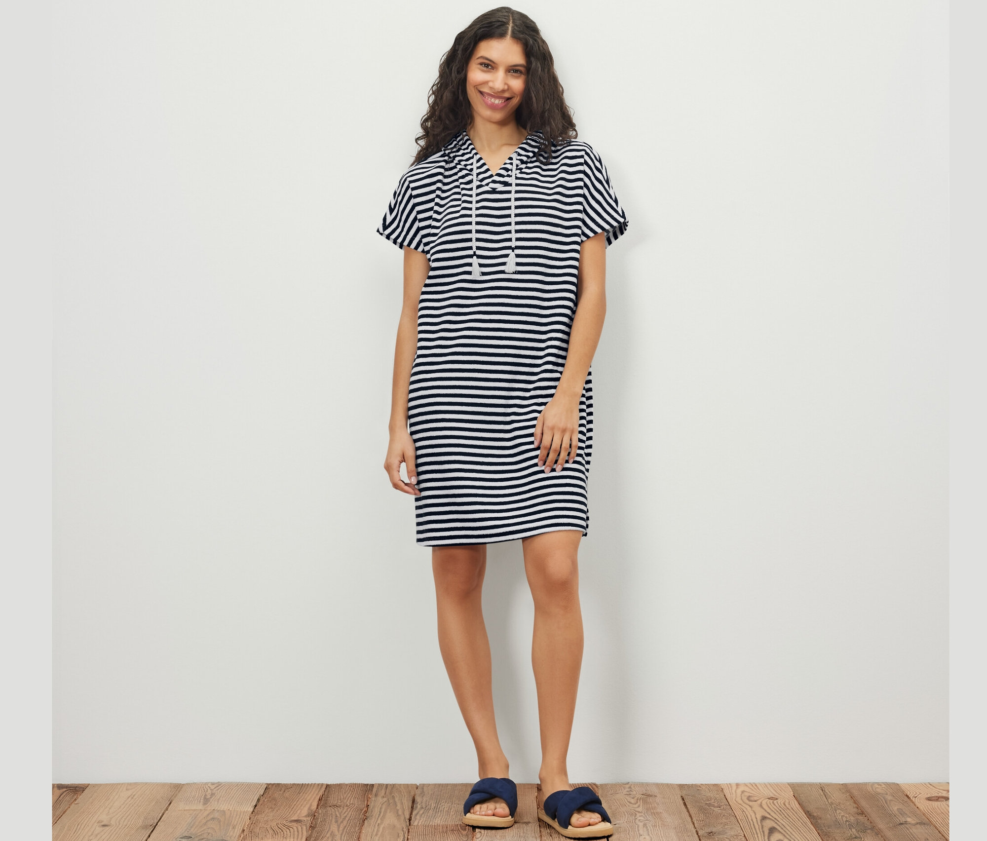 Kadın çizgili havlu kumaş plaj elbisesiyle poz veriyor.