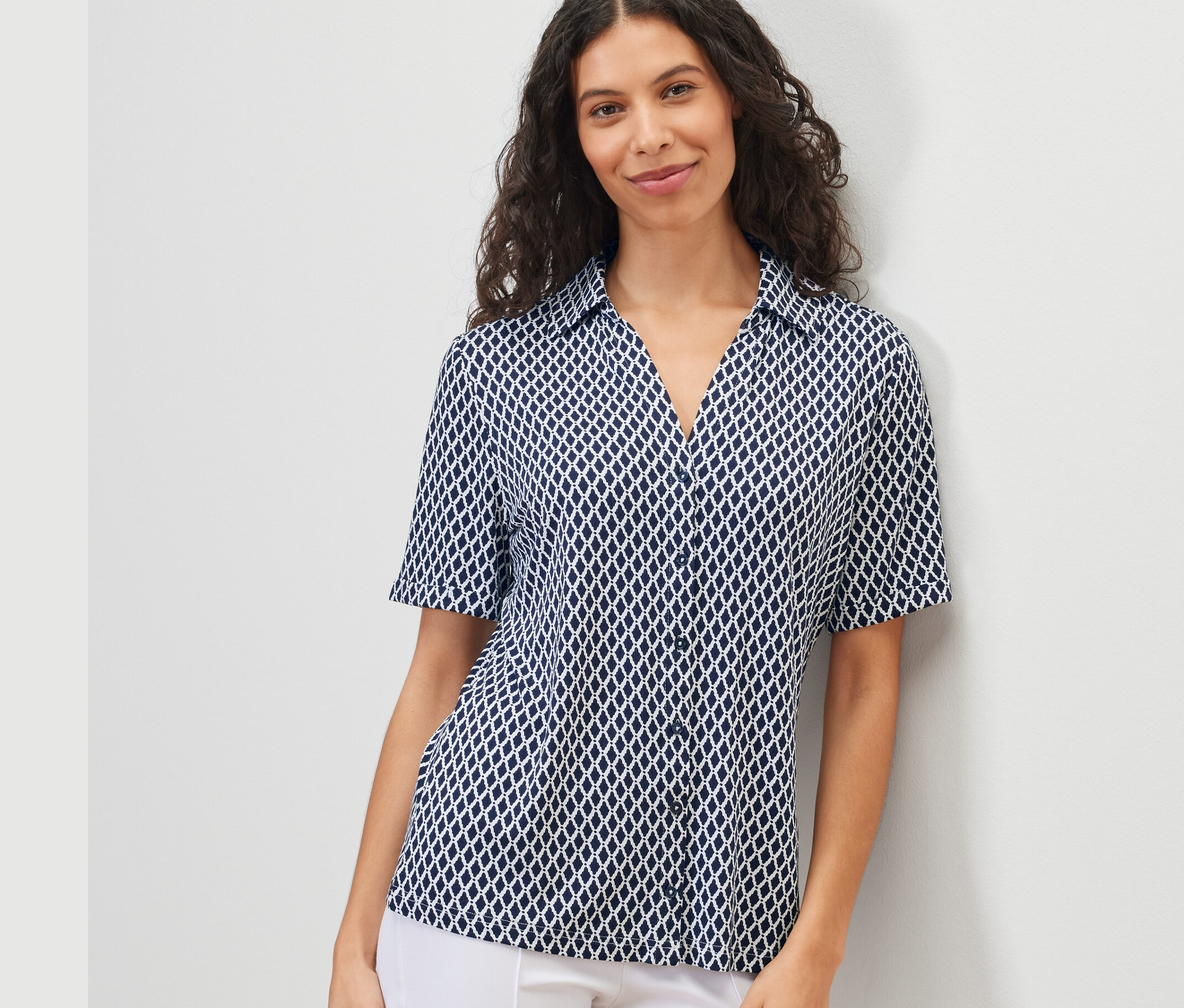 Kadın baskılı düğmeli bluz giyiyor.