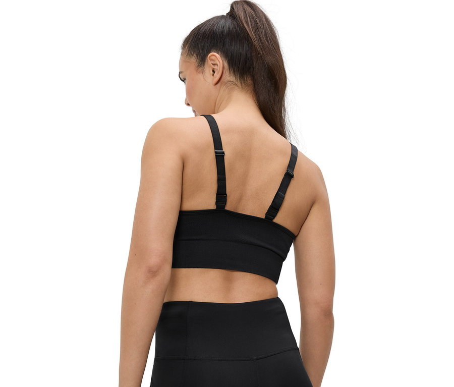 Atkuyruklu, siyah spor sutyeni ve tayt giyen bir kadının arkadan görünümü.