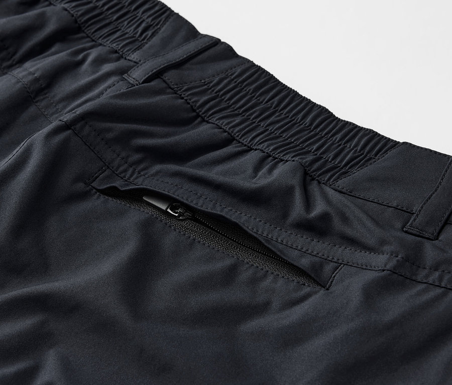 Siyah renkli, fermuarlı cepli 2'si 1 arada fonksiyonel pantolonun yakın çekim görüntüsü.