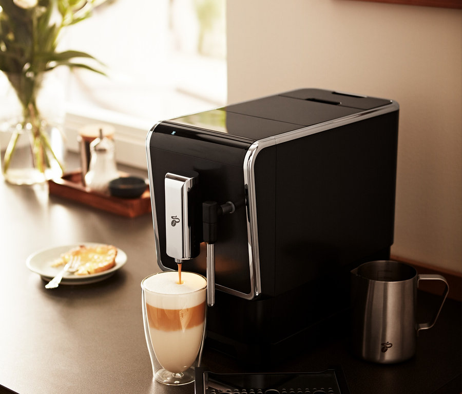Tchibo »Esperto Latte« Antrasit Tam Otomatik Kahve Makinesi bir bardağa içecek hazırlıyor.