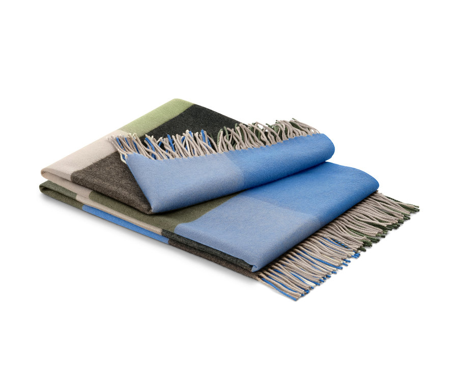 Yeşil, bej, kahverengi ve mavi renklerde, saçaklı, katlanmış bir battaniye.