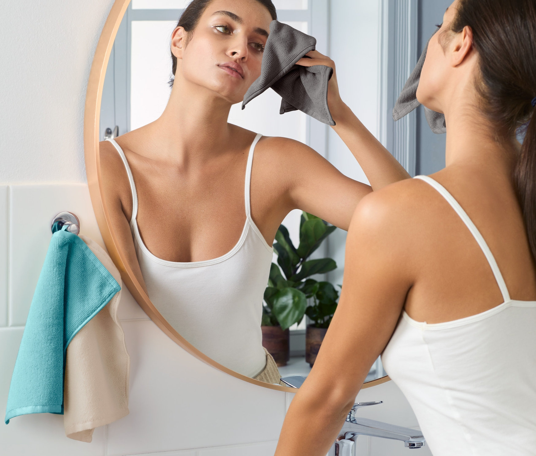 Kadın banyoda yüzünü 3 Adet Yüz Temizleme Bezi ile temizliyor.