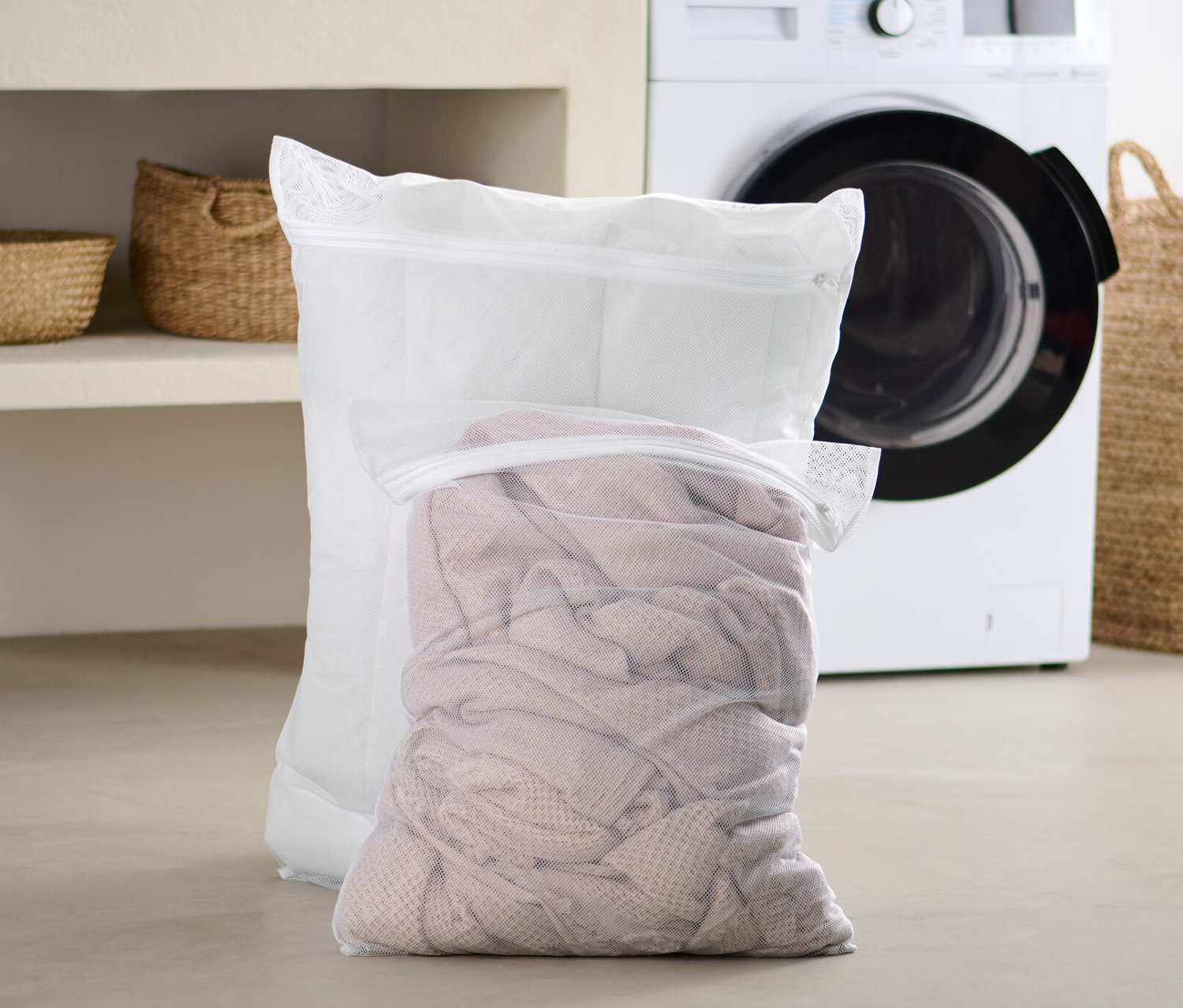 İki adet ekstra büyük çamaşır filesi banyoda çamaşır makinesinin önünde duruyor.