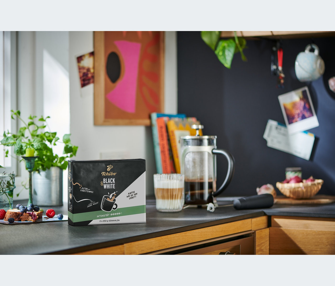 Mutfak tezgahında bir paket BLACK & WHITE - 2 x 250 g öğütülmüş kahve, bir French press ve bir bardak kahve duruyor.