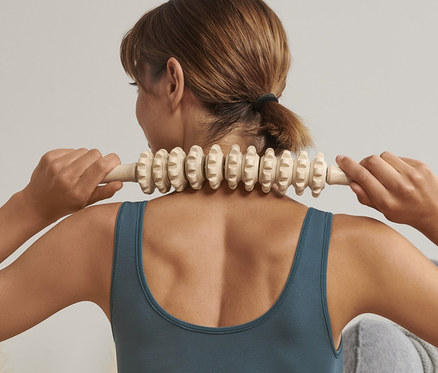 Kadın boynunda Tahtadan Masaj Çubuğu kullanıyor.