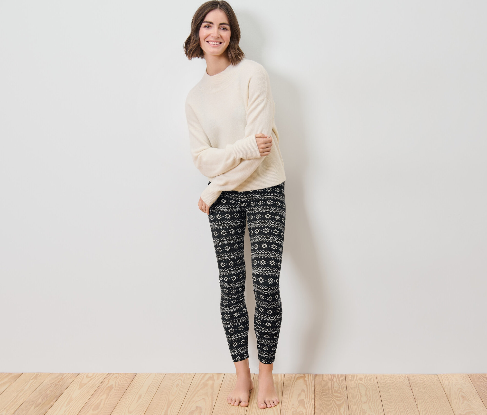 Kadın ayakta duruyor ve Norveç Baskılı Tayt giyiyor.