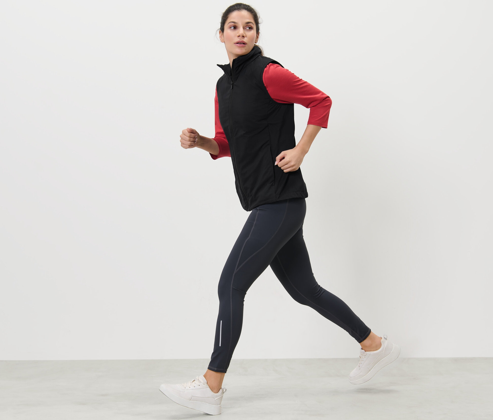 Koşu yeleği giyen kadın koşuyor.