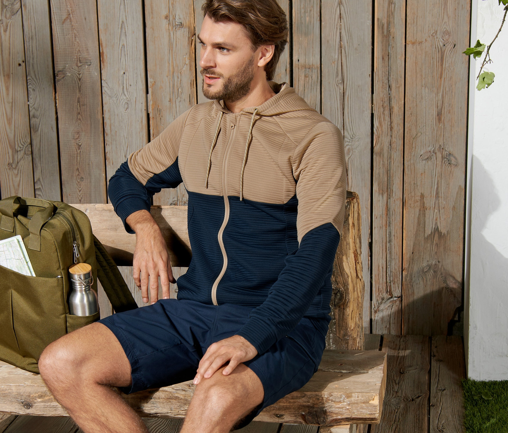 Adam bankta oturuyor ve Fonksiyonel Ceket giyiyor.