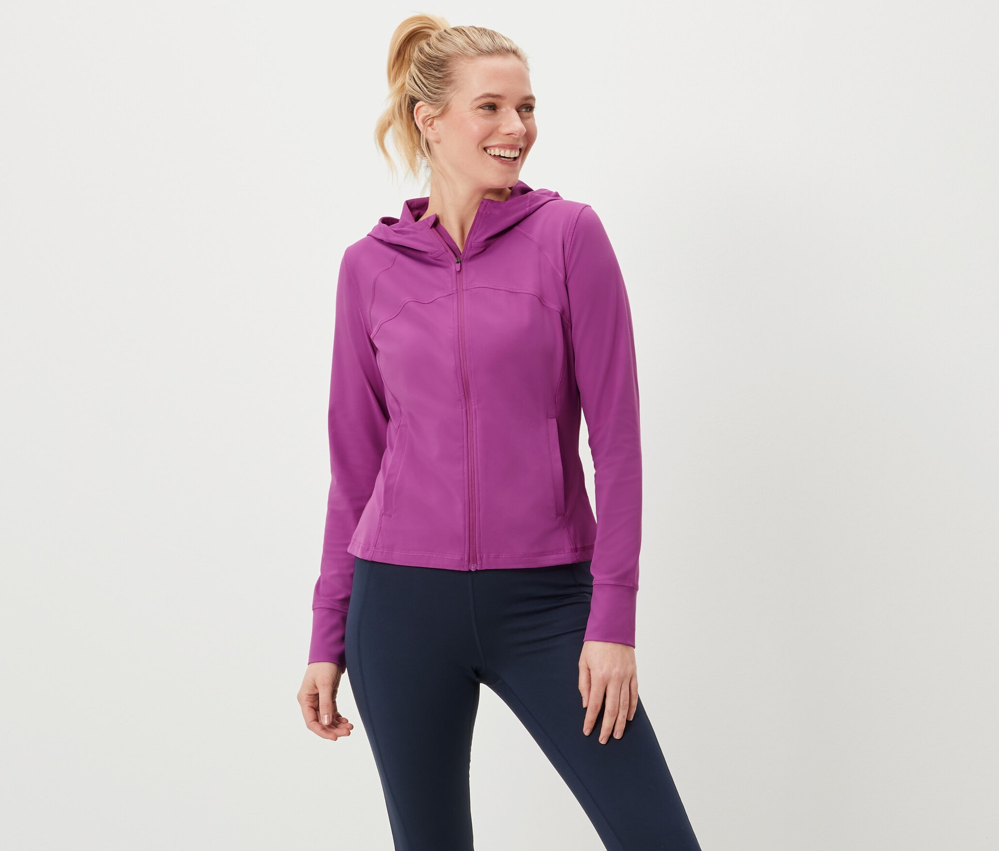 Kadın bir spor ceketi ve tayt giyiyor.