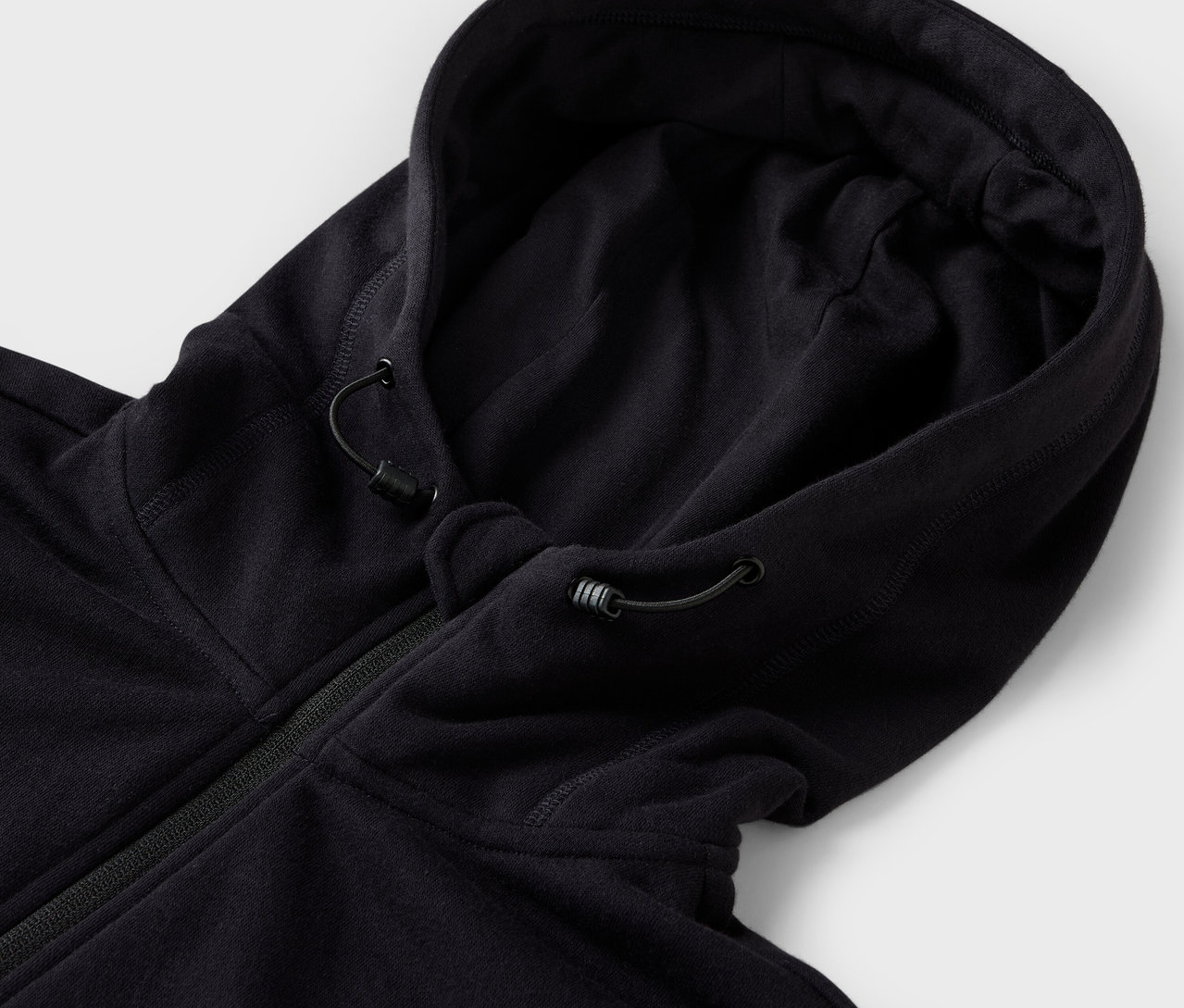 Siyah kapüşonlu bir sweatshirt'ün detay görüntüsü, kapüşonunda büzgü ipleri bulunuyor.