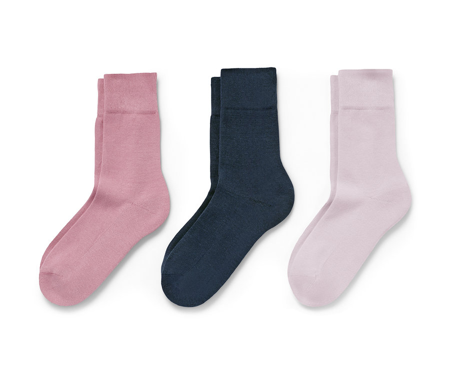 Beyaz bir arka plan üzerinde pembe, lacivert ve açık pembe olmak üzere üç çift çorap.