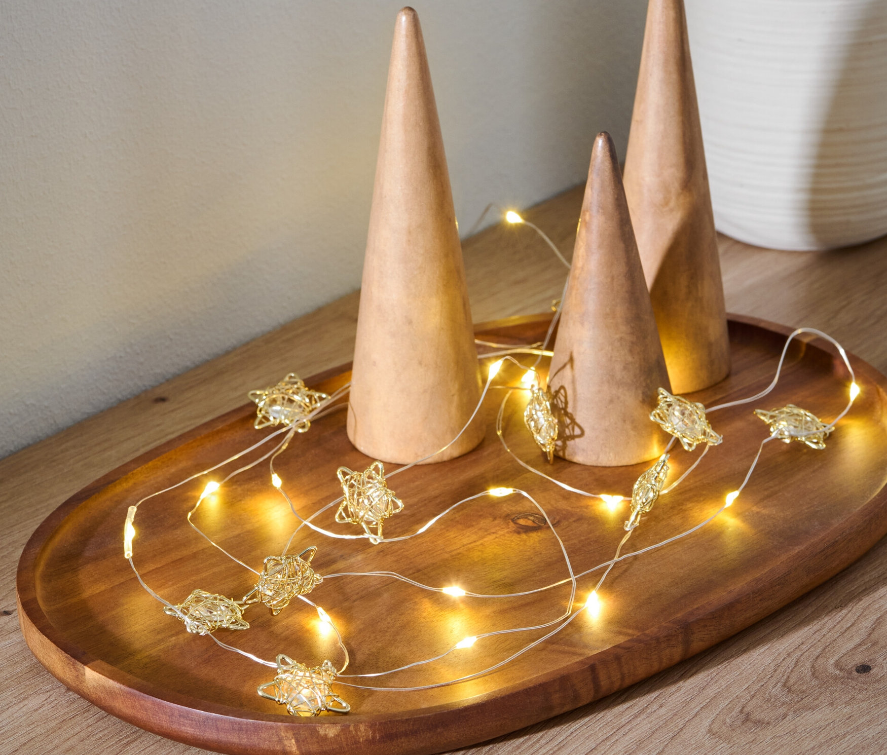 Ahşap bir tepside üç adet ahşap koni ve yıldız şeklinde bir LED Işık Zinciri bulunmaktadır.