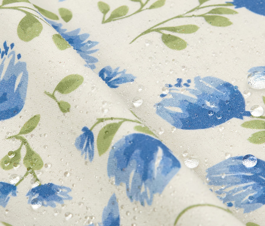 Mavi çiçekli ve su damlalı, yaklaşık 90 x 90 cm boyutlarındaki silinebilir masa örtüsünün yakın çekimi.