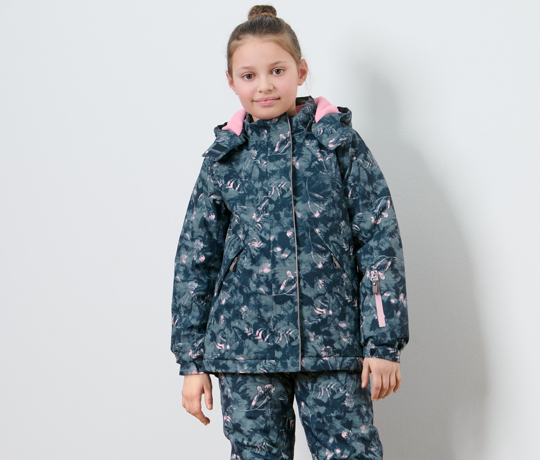 Kız çocuk desenli çocuk kayak montuyla poz veriyor.