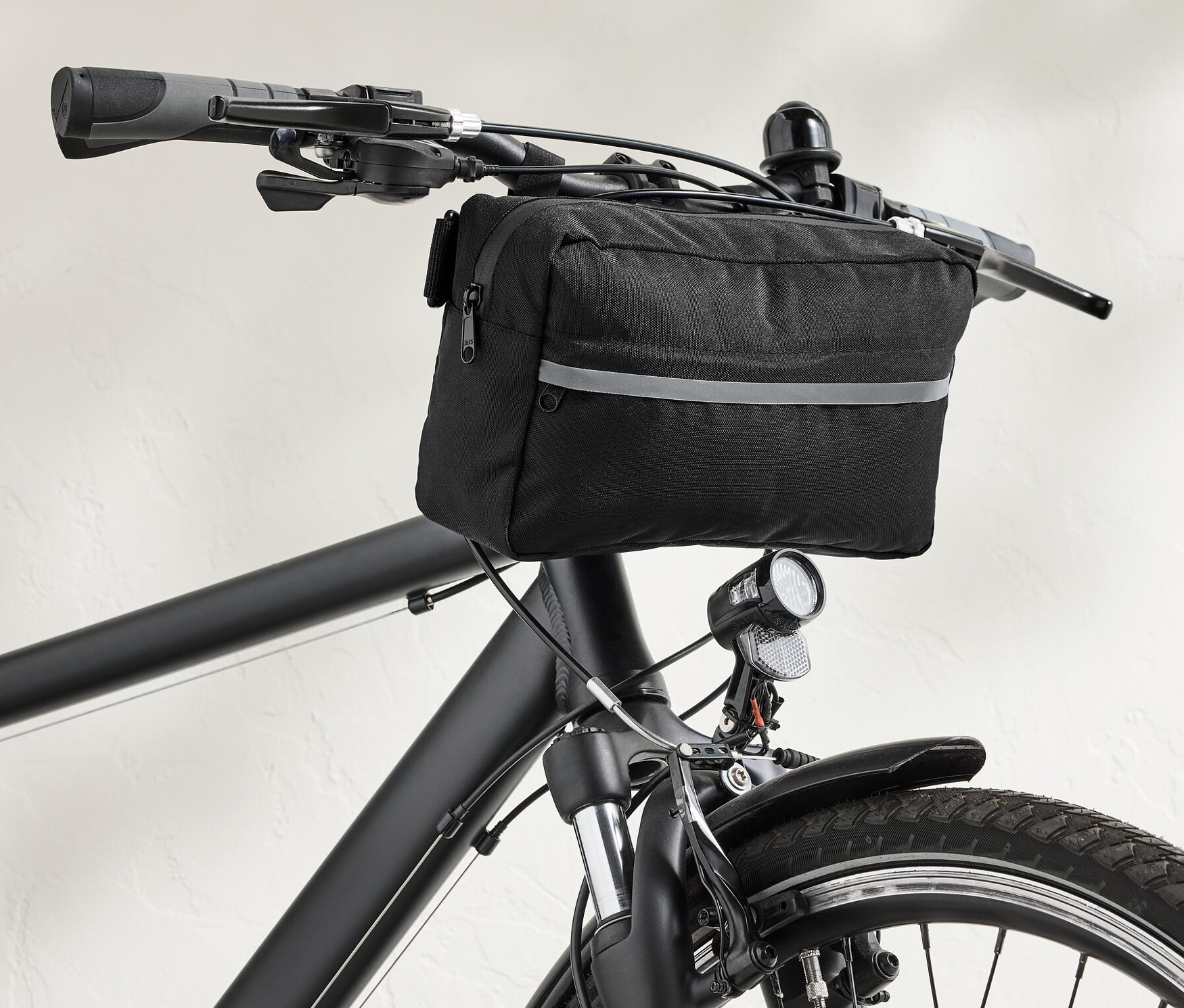 Siyah bisikletin gidonunda siyah bir 2'si 1 arada gidon çantası.