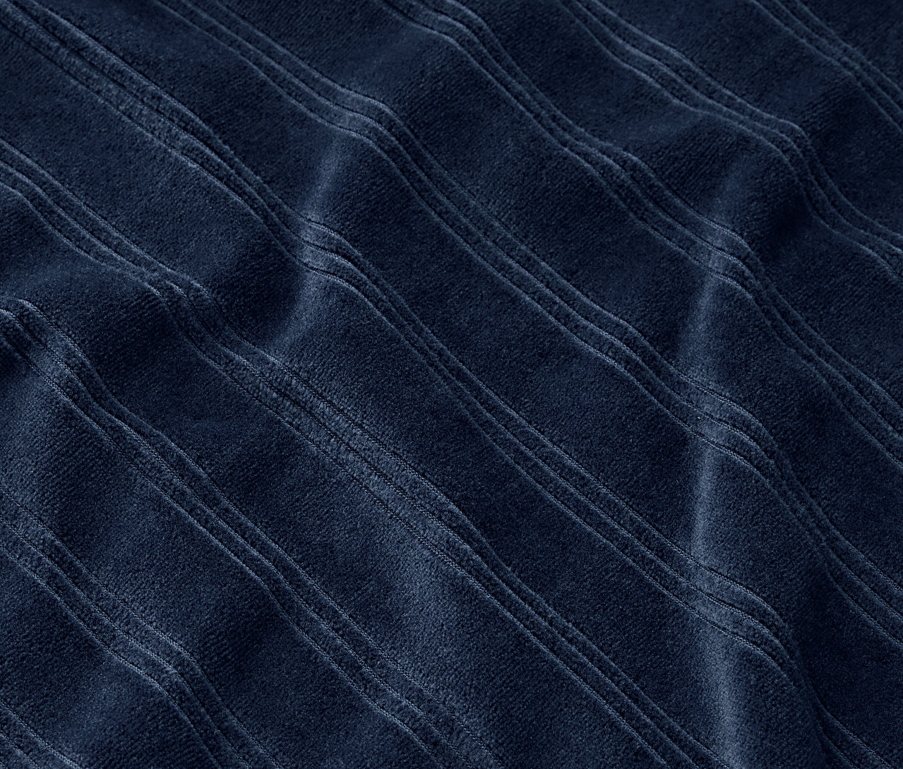Kabartmalı şeritlere sahip lacivert bir kumaşın yakın çekimi.