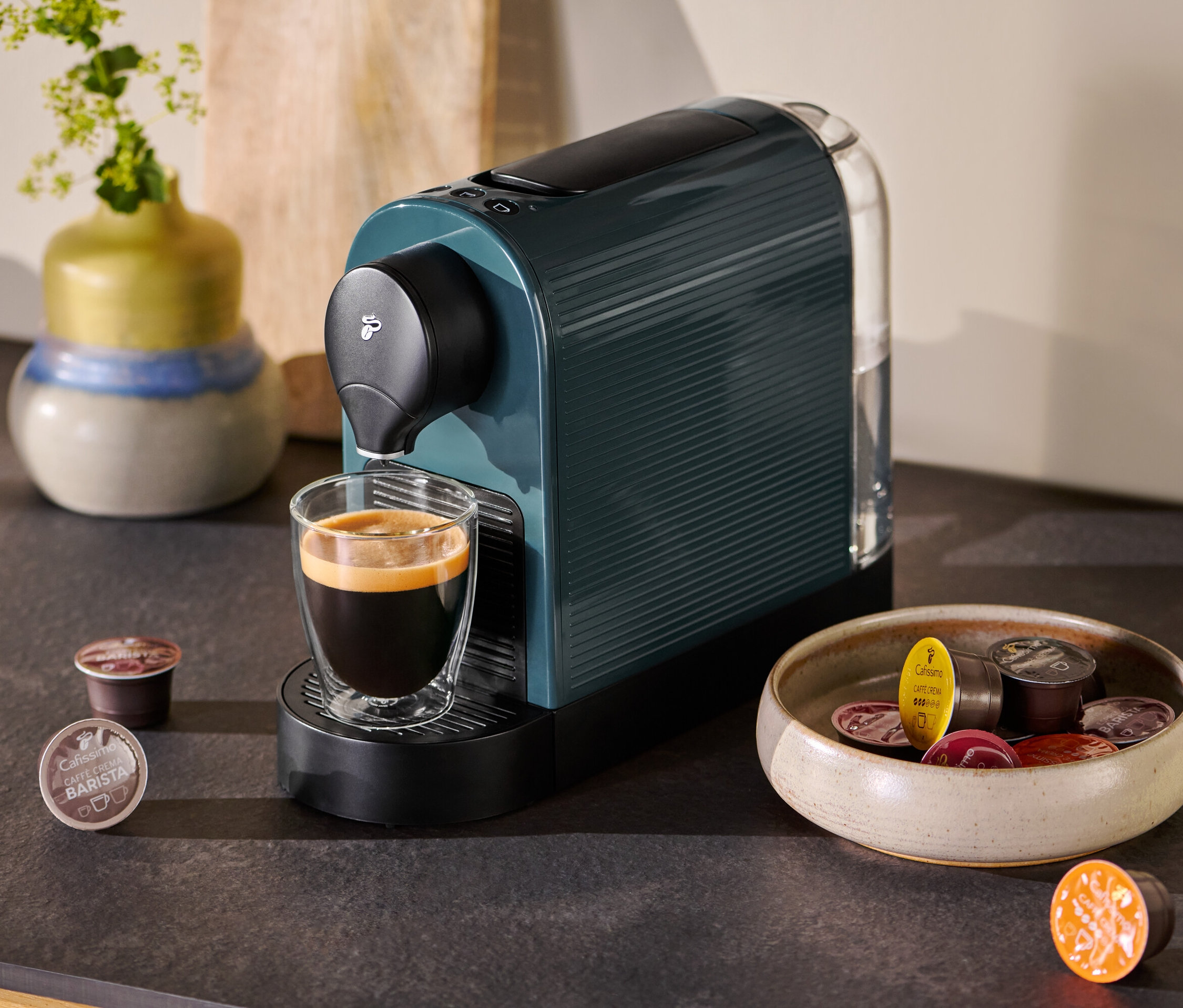 Petrol Cafissimo pure kahve makinesi, bir fincan kahve ve kapsüllerle birlikte.