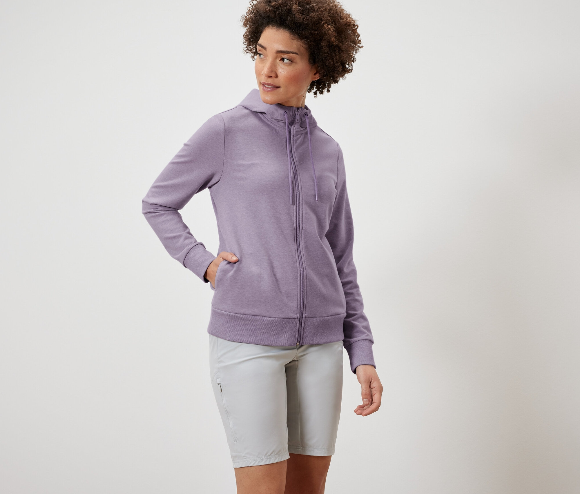 Kadın mor Sweat Mont ve gri şort giyiyor.
