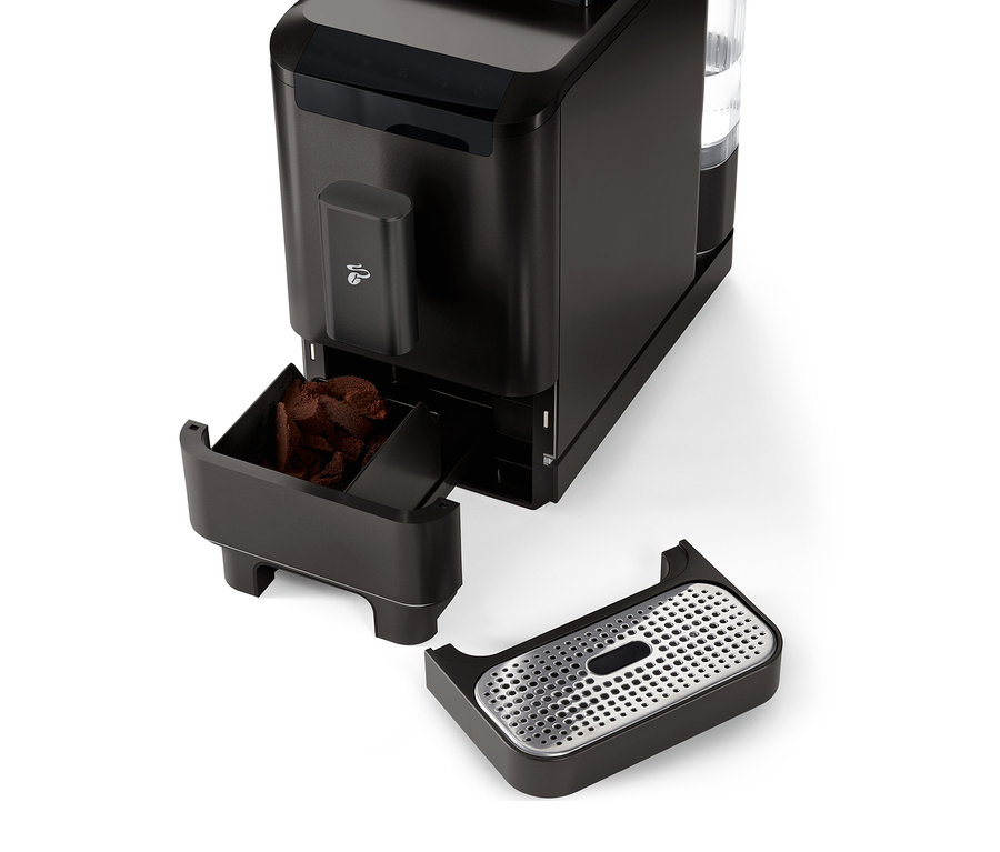 Granit Siyah renkli »Esperto2 Caffè« tam otomatik kahve makinesinin, çıkarılmış kahve posası haznesi ve damlama tepsisi ile yakın çekimi.