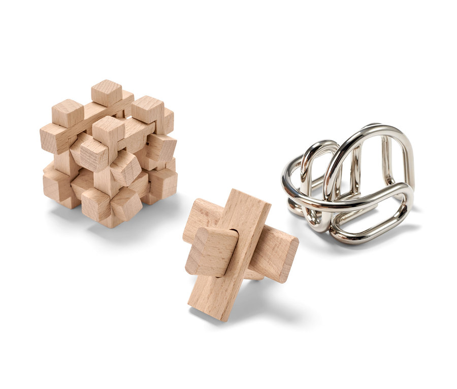 Beyaz arka planda üç adet beceri oyunu. İkisi ahşap, biri metal.