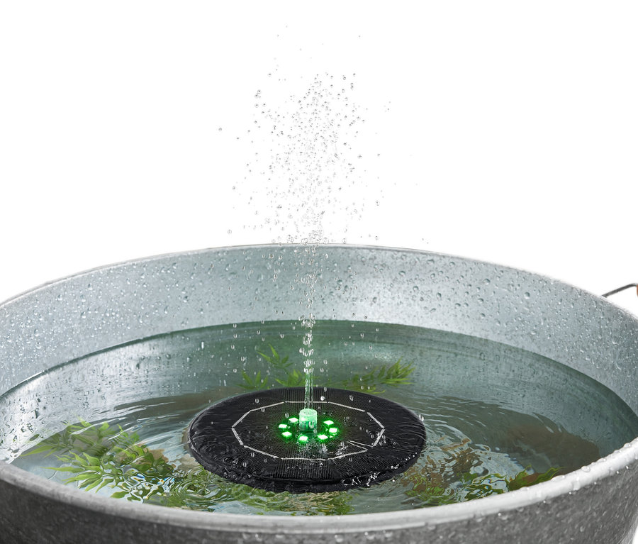Metal bir kovadaki suda yüzen, ışıklı güneş enerjili fıskiye.