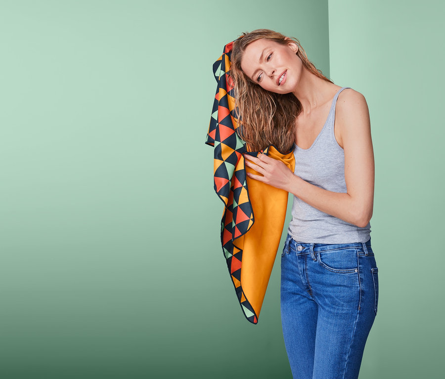 Kadın, saçını çok renkli, yaklaşık 50 x 100 cm boyutlarındaki outdoor el havlusuyla kuruluyor.