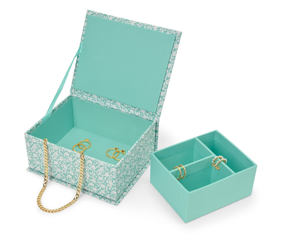 İçinde altın kolye ve yüzükler bulunan, açık, çiçek desenli, mavi-yeşil mücevher kutusu, yanında mavi-yeşil bir mücevher düzenleyici.