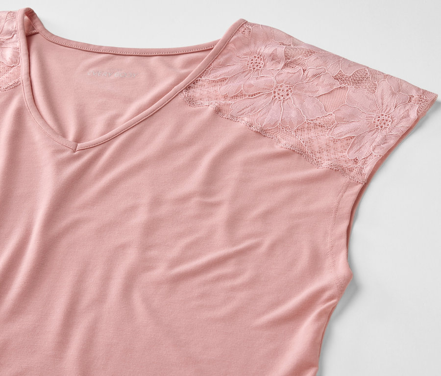 Pembe renkli, dantel kollu bir bluzun yakın çekimi.