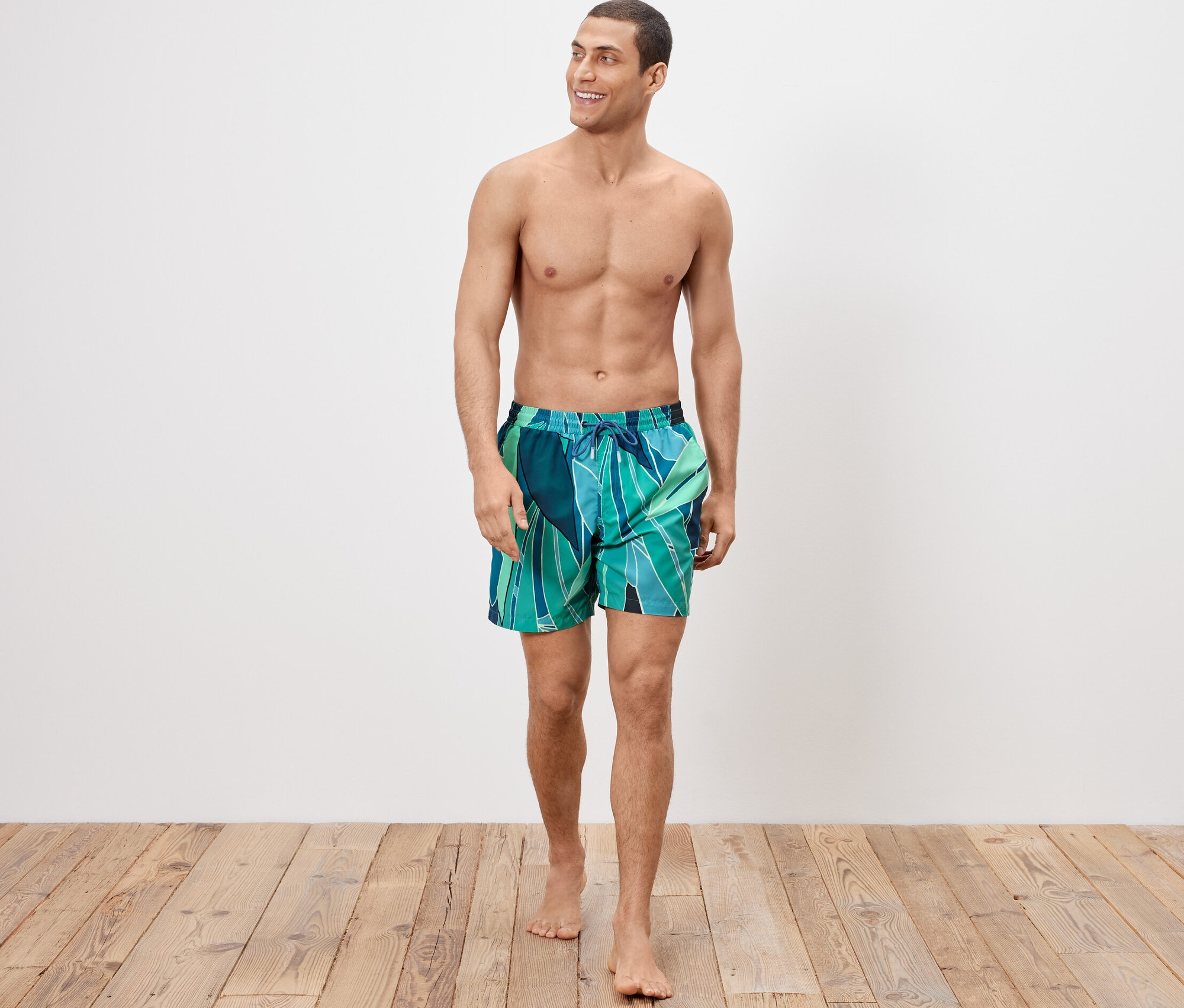 Adam şort mayo giyiyor ve yürüyor