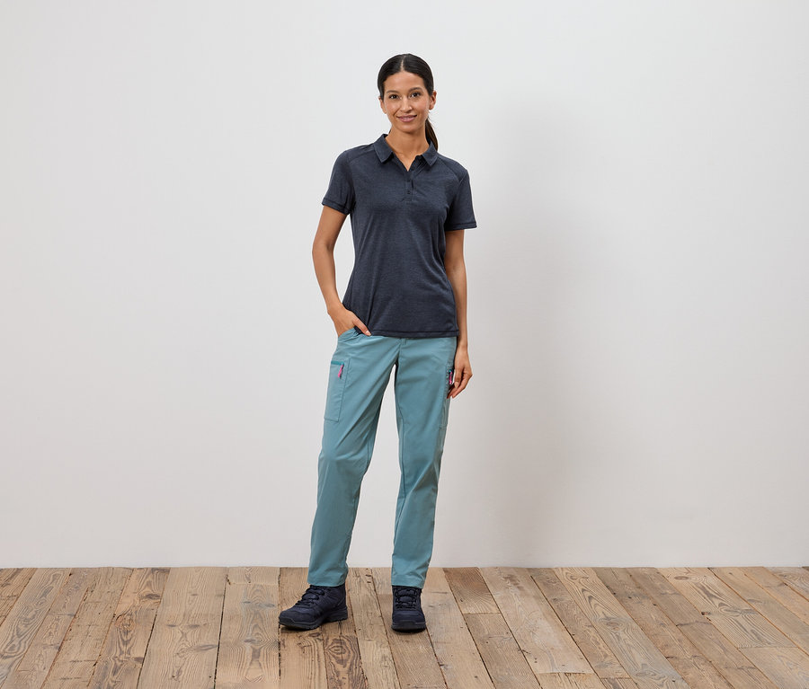 Bir kadın eli cebinde beyaz bir duvarın önünde duruyor.