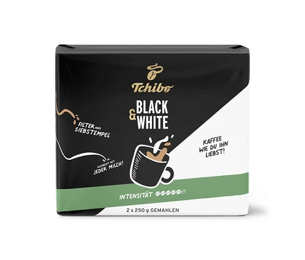 Siyah ve beyaz Tchibo BLACK & WHITE 500 g öğütülmüş kahve paketi, üzerinde kahve ve süt köpüğü olan bir fincan illüstrasyonu.