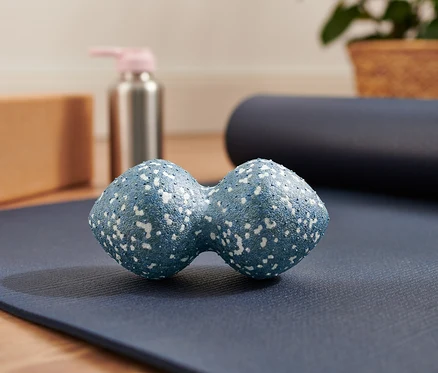 Mavi renkli ikili masaj topu, mavi yoga matının üzerinde duruyor.