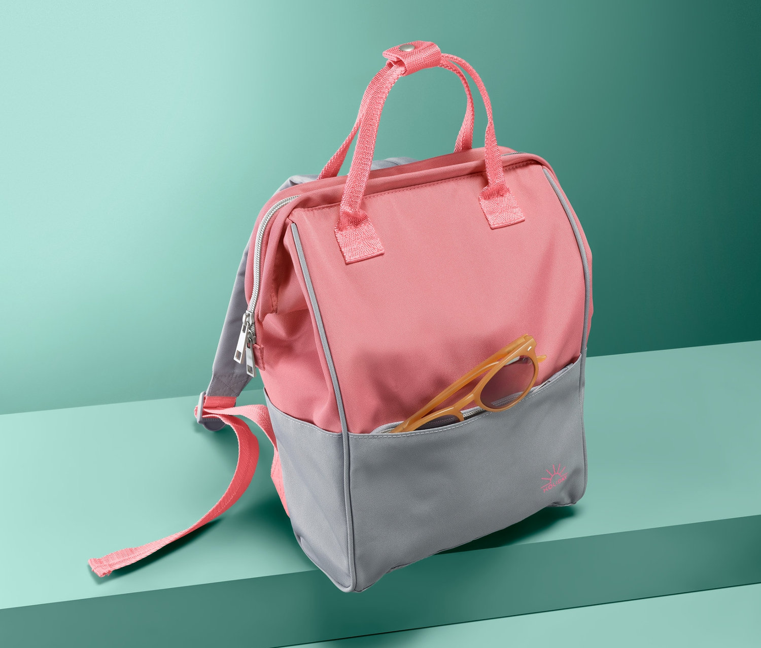 Turkuaz arka planda cebinde gözlük olan, açık pembe-gri emniyetli sırt çantası.