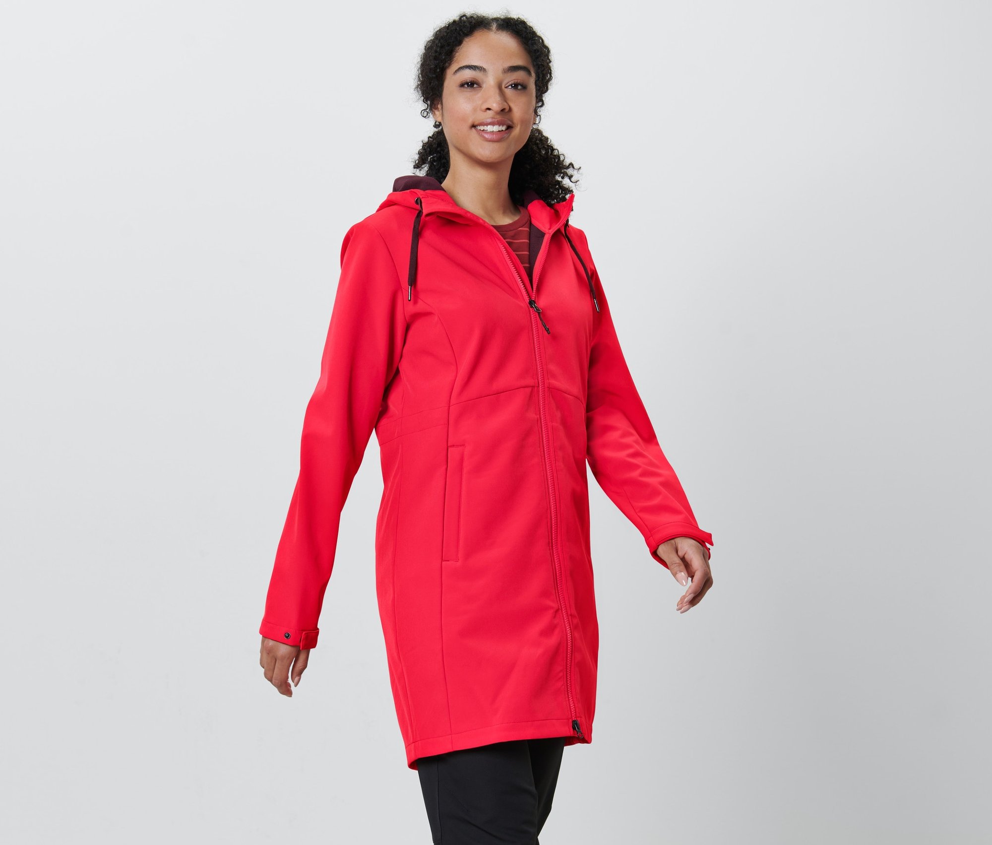 Kadın kırmızı softshell mont giyiyor.