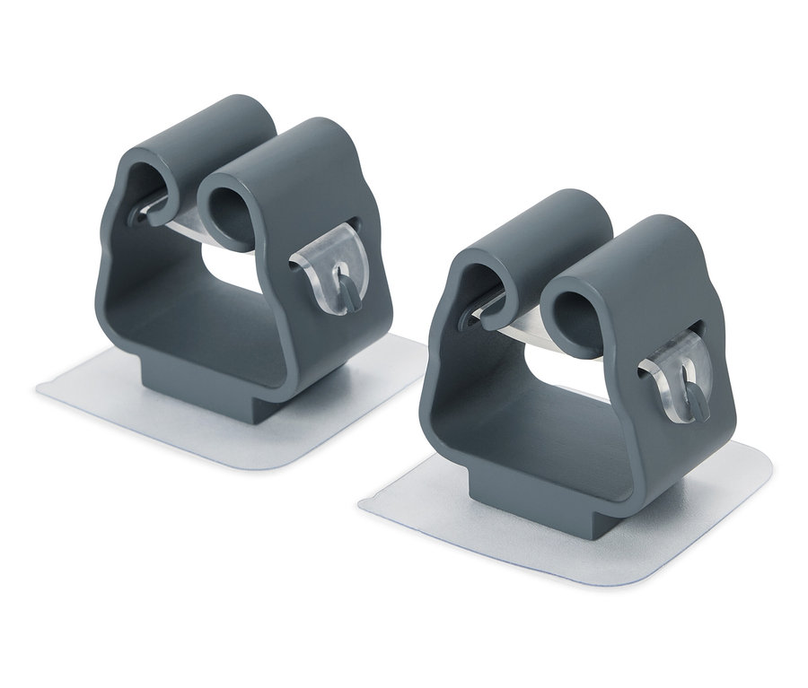 Yapışkanlı pedlere sahip iki adet gri paspas tutucu.