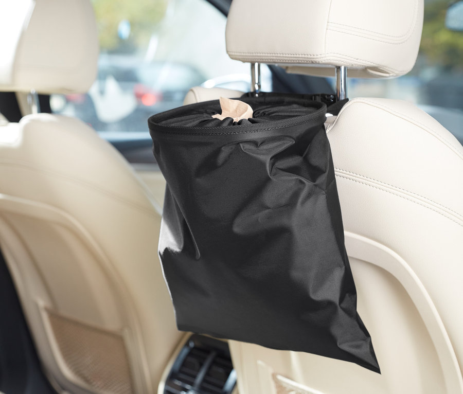 Arabada, koltuk başlığında asılı duran siyah bir Universal Çöp Kovası.