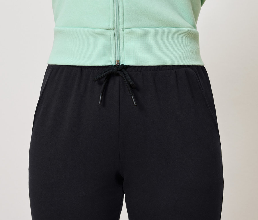 Siyah eşofman altı, büzgülü ve açık yeşil sweatshirt.