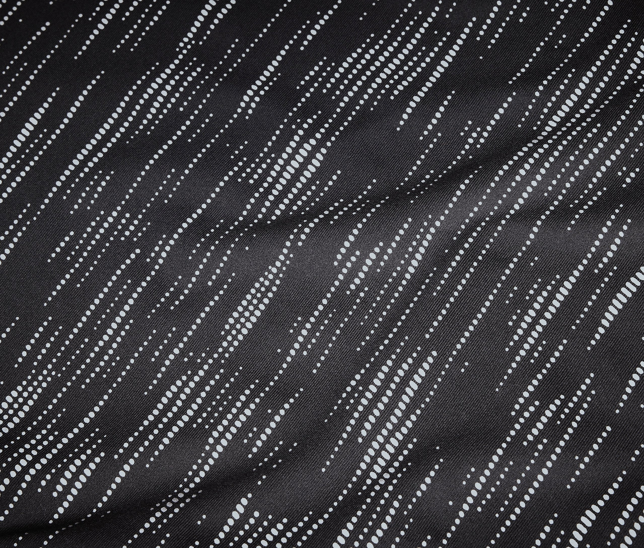 Çapraz, noktalı, beyaz çizgili siyah kumaşın yakın çekimi.