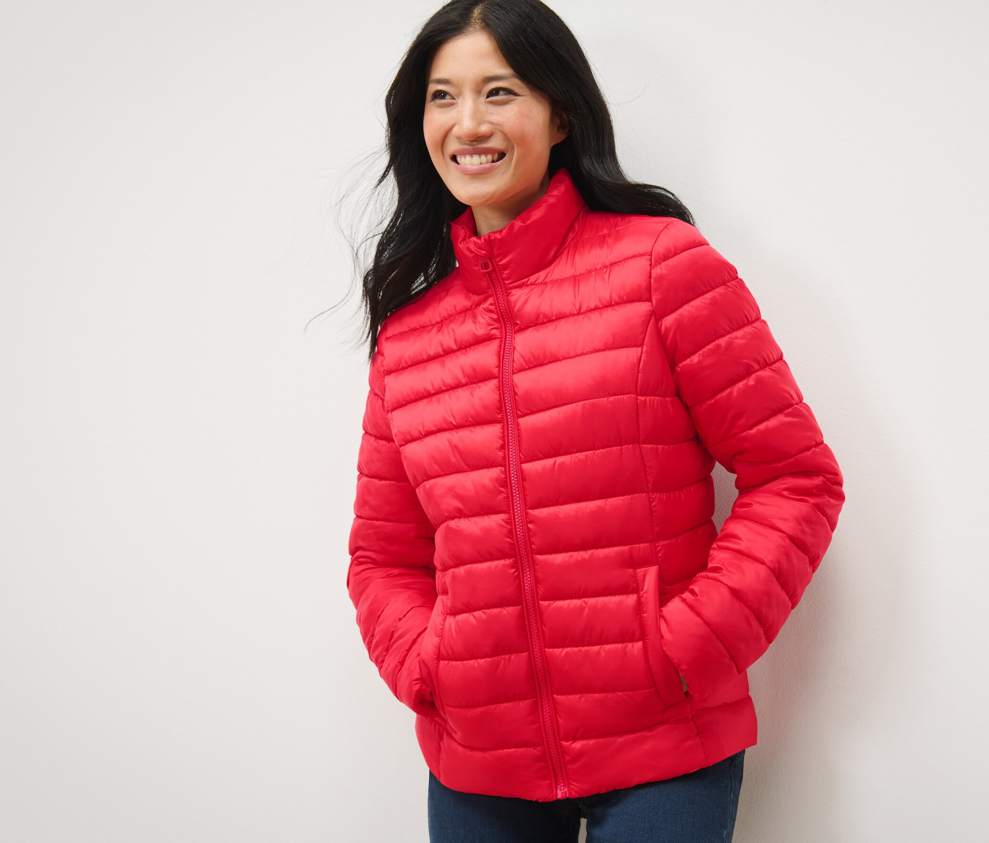 Kadın kırmızı kapitone montuyla gülümsüyor ve poz veriyor.