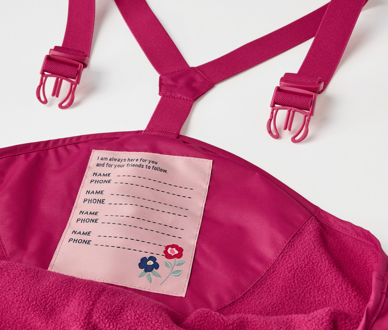 Çocuk termo yağmur pantolonu, ahududu renginde, askılı ve isim etiketli detay.