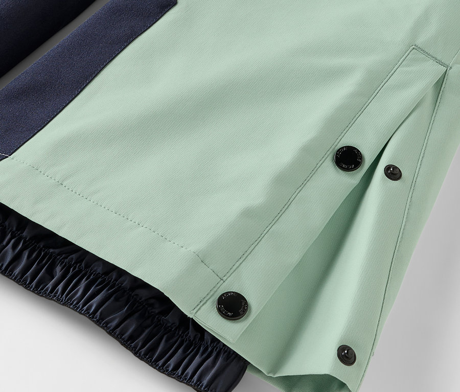 Düğmeli kapamalı ve lastikli kenarlı açık yeşil pantolon detayı.