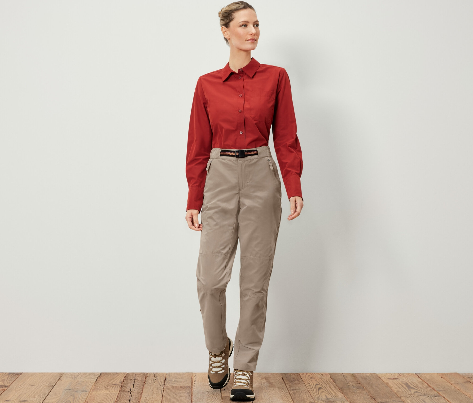 Kadın Sivrisinek Korumalı Outdoor Pantolon, kahverengi gömlek ve yürüyüş ayakkabıları giyiyor.